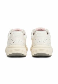 Baskets blanches avec une tige en mesh texturé, accents roses sur le col et des détails perforés. Semelle épaisse de couleur crème avec un motif de traction.