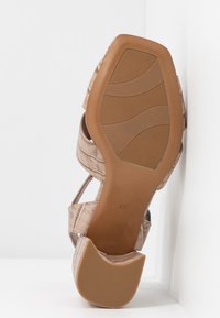 Talons et semelle de sandale avec texture crocodile beige, semelle extérieure en caoutchouc avec rainures, taille 37, présenté sur fond blanc.