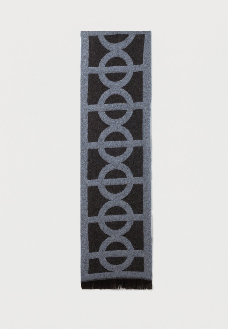 Wełniany szal z geometrycznym wzorem kołowym w jasnoszarym i ciemnoszarym kolorze, z frędzlami na końcach. Kształt prostokątny, miękka tekstura.