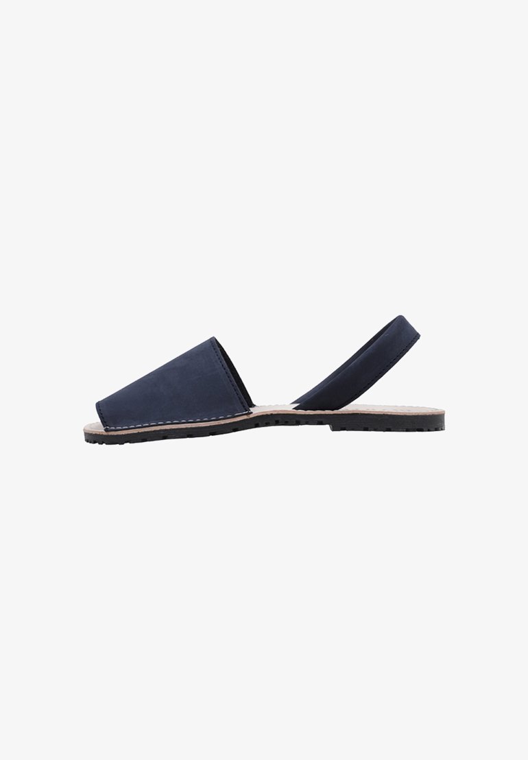 Sandalias de cuero azul marino tipo slip-on con una parte delantera sólida y una correa trasera, que presentan una suela texturizada para mayor agarre y detalles de costura alrededor de los bordes.
