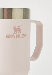 Roza nehrđajuća čelična šalica s teksturiranim mat završetkom, metalnim poklopcem i istaknutim logotipom koji prikazuje lava s krilima.