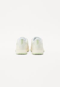 Sneaker mit einem hellcremefarbenen Mesh-Obermaterial, pastellgrünen Akzenten, gepolstertem Kragen und strukturierter Sohle. Hat ein minimalistisches Design und keine sichtbaren Logos.
