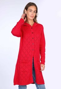 Roter Strickcardigan mit einem Rautenmuster, Kapuze, vier Knöpfen und seitlichen Taschen. Mit gerippten Bündchen und Saum.