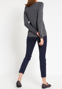 Šedý dlouhý rukáv, přiléhavý v pase, spárovaný s námořnickými štíhlými kalhotami. Outfit doplňují tmavě šedé baleríny.