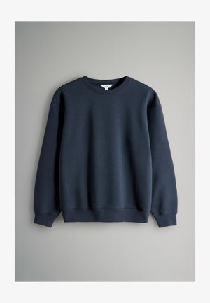 Tume sinine pusa ümara kaelusega, pika varruga, soonikkoes mansettide ja äärega, valmistatud pehmest, sileda tekstuuriga kangast.