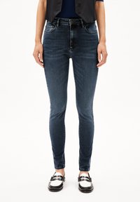 Smala blå denimjeans med medelhög midja. Har fem fickor och subtila blekningar. Mjuk textur med en klassisk design.