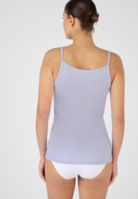 Top de tirantes sin mangas de color púrpura claro, con tirantes finos; presenta una textura suave y elástica y un diseño de espalda redondeada.