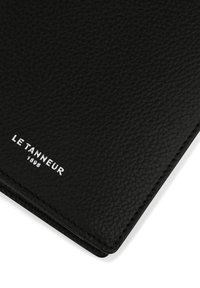 Black leather wallet with a textured finish. Features embossed "LE TANNEUR 1898" logo in silver. Smooth edges and clean stitching accents.