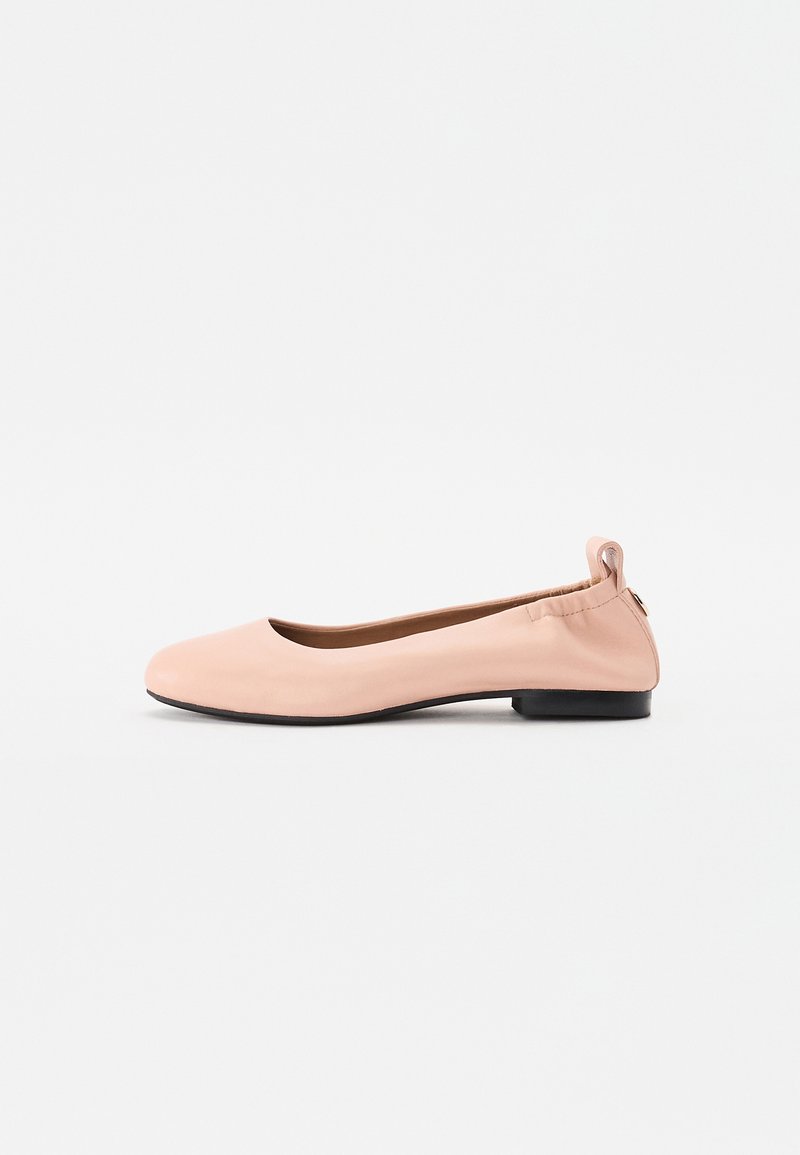 Lys rosa ballerinasko laget av glatt materiale med avrundet tå, fleksibel bakdel og en liten svart hæl.