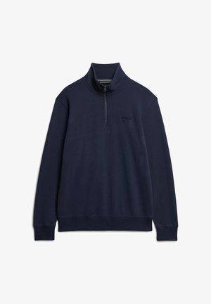 Granatowy polarowy sweter z wysokim kołnierzem, z suwakiem na ćwierć długości z przodu oraz haftowanym logo na piersi. Miękka tekstura i luźny krój.