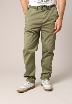 Olijfgroene cargo broek met een relaxed fit, elastische tailleband en trekkoord. Zachte stof, zichtbare zakken en geplooide details.