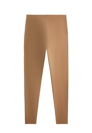 Rekbare beige slim-fit legging met een gladde textuur zonder zichtbare sluitingen of patronen, plat weergegeven op een witte achtergrond.