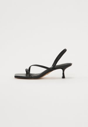 Black strappy sandal with a square toe, thin straps, and a short block heel. Smooth leather surface and minimalist design.