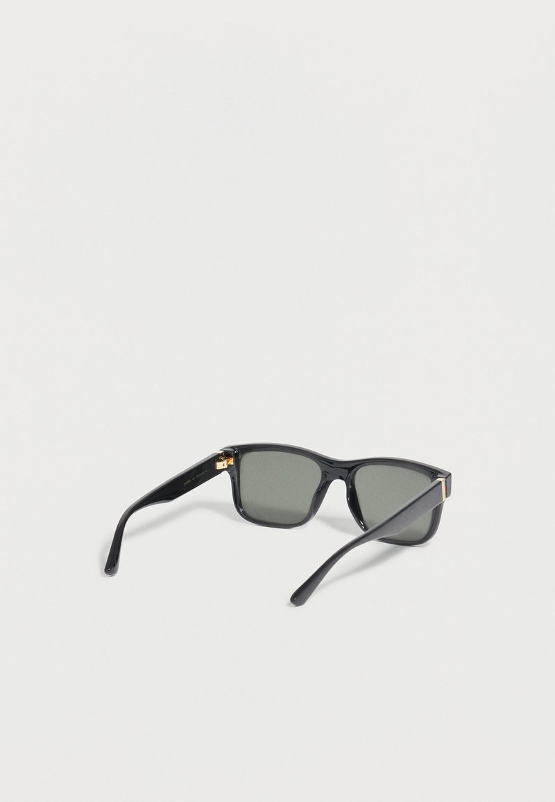 Black rectangular sunglasses with dark lenses and slightly curved temple arms lying open on a plain light surface.