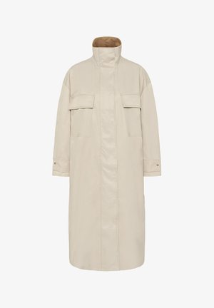 Pikk beež mantel kõrge kraega, kahe rinna flapi taskuga, nööbitavate varrukasoomustega ja pruuni sametise sisemise voodriga krae juures.