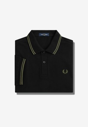 Polo negro con doble raya verde oliva en el cuello y las mangas, tapeta de botones y pequeño logotipo de corona de laurel en el pecho.