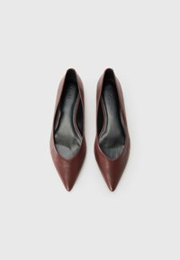 Pair of brown pointed-toe leather flats with black insoles branded "HUGO," placed side by side on a white background.