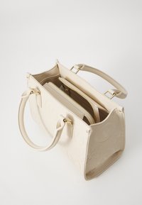 Beige Lederhandtasche mit geprägt Logo, doppelten Obergriffen, goldenen Beschlägen und Reißverschlussfächern innen. Glatte Textur und strukturierte Form.