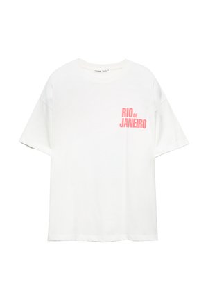 T-shirt en coton blanc avec des manches courtes et un col rond. Présente un texte rose indiquant "RIO de JANEIRO" sur le côté gauche.