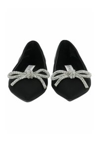 Chaussures noires plates avec des bouts pointus, ornées d'un accent en nœud en strass argenté brillant sur chaque chaussure, fabriquées en matériau lisse.
