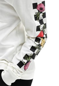 Witte lange mouwen sweatshirt met kleurrijke bloemgrafieken langs de mouwen en een geruit patroon. Zachte katoenen stof.