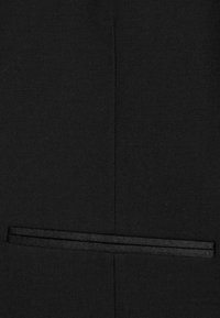 Tela negra con una textura fina, con un detalle de franja negra horizontal. La tela presenta una apariencia limpia y estructurada.
