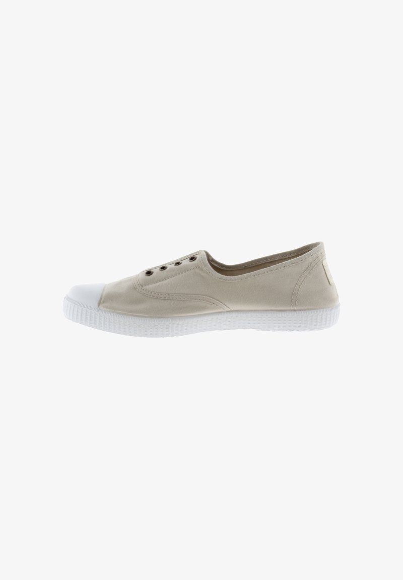 Sneaker in tela beige con punta e suola in gomma bianca, dotata di sei fori per lacci e un design minimalista.