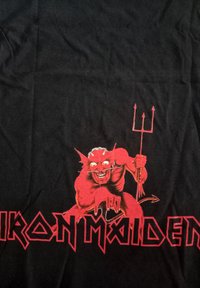 Černé bavlněné tričko s červenou démonickou postavou držící trojzubec, s logem "IRON MAIDEN" v velkých červených písmenech níže.
