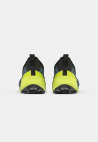 Αθλητικά παπούτσια με μαύρο και μπλε επάνω μέρος, κίτρινες λεπτομέρειες, υφασμάτινες σόλες με υφή για πρόσφυση και επένδυση στον γαμπό για άνεση. Πίσω όψη.