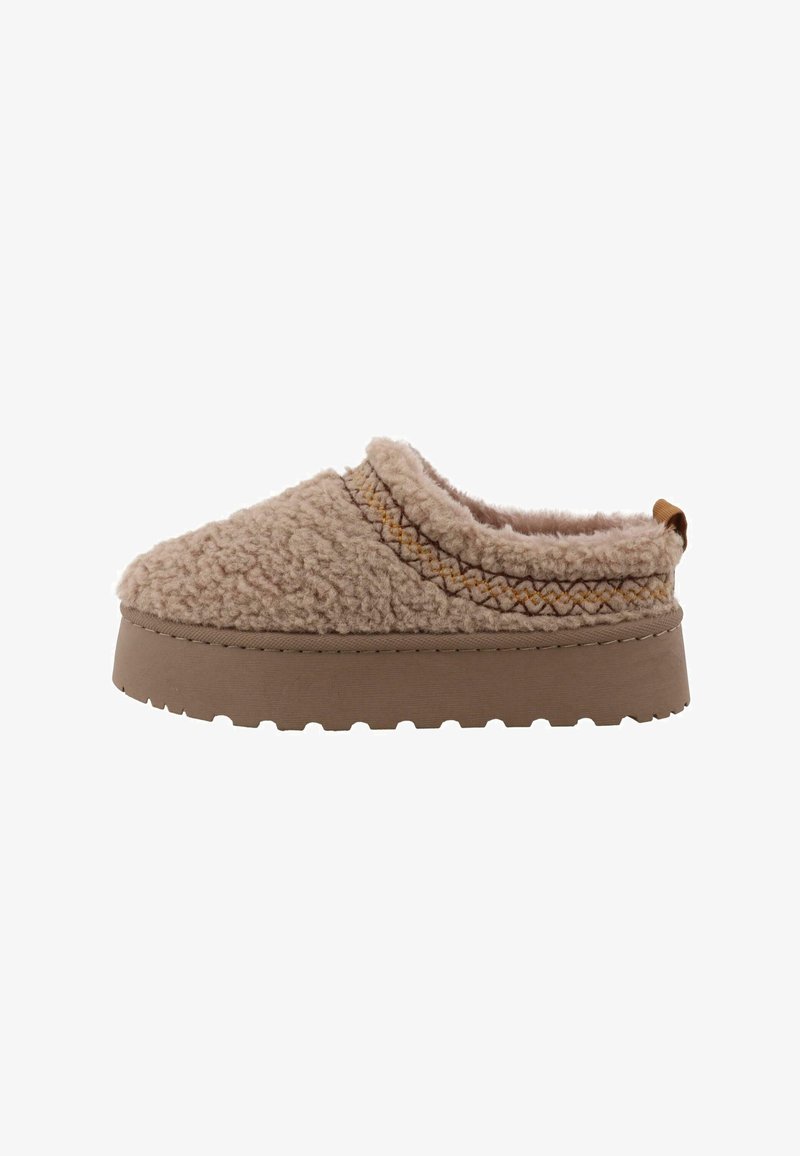 Beige slof met een fluffy, gestructureerde bovenmateriaal en een bruine rubberen zool. Inclusief een decoratieve stiknaad en een kleine hieltab.