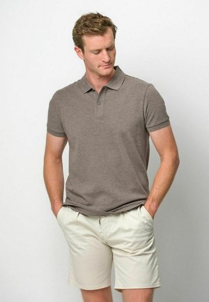 Polo marrón con cuello clásico, mangas cortas y tapeta con dos botones, combinado con pantalones cortos beige claro. Textura de tela suave.