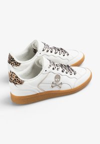 Baskets blanches avec un dessus en cuir texturé, des accents imprimé léopard sur le talon et un logo en forme de crâne. Semelle en caoutchouc gum et lacets à motifs.