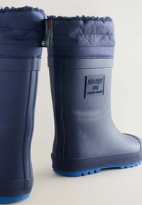 Bottes en caoutchouc navy avec un revers matelassé et rembourré en tissu assorti. Semelles texturées bleues pour une meilleure adhérence. Présente un logo en relief sur le côté.