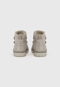 Bottes de cheville synthétiques grises avec un subtil éclat, présentant des détails perforés, des sangles Velcro et une semelle en caoutchouc texturée.