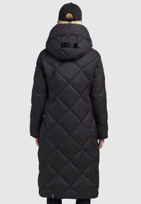 Long black puffer coat with a quilted diamond pattern, hood, and back logo detail. Made of smooth, insulated fabric, extending past the knees.