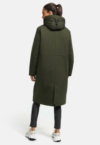 Dark green parka with a hood, featuring a drawstring closure, long sleeves, and a relaxed fit. Smooth texture and mid-thigh length.