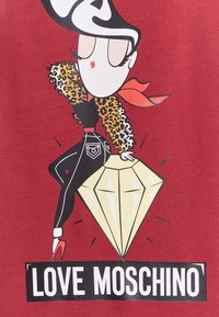 Gráfico que presenta un personaje estilizado con acentos de estampado de leopardo, una bufanda roja, pantalones negros y un gran diamante, todo ello sobre un fondo rojo.