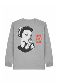 Chemise grise à manches longues avec un visage de femme en noir et blanc soufflant un baiser et un texte rouge disant "OUPS JE M'EN FICHE" au dos.