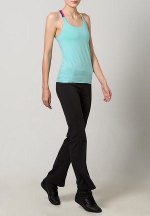 Débardeur turquoise clair avec bretelles multicolores, associé à un pantalon de sport noir et des baskets noires. Texture lisse, coupe ajustée.