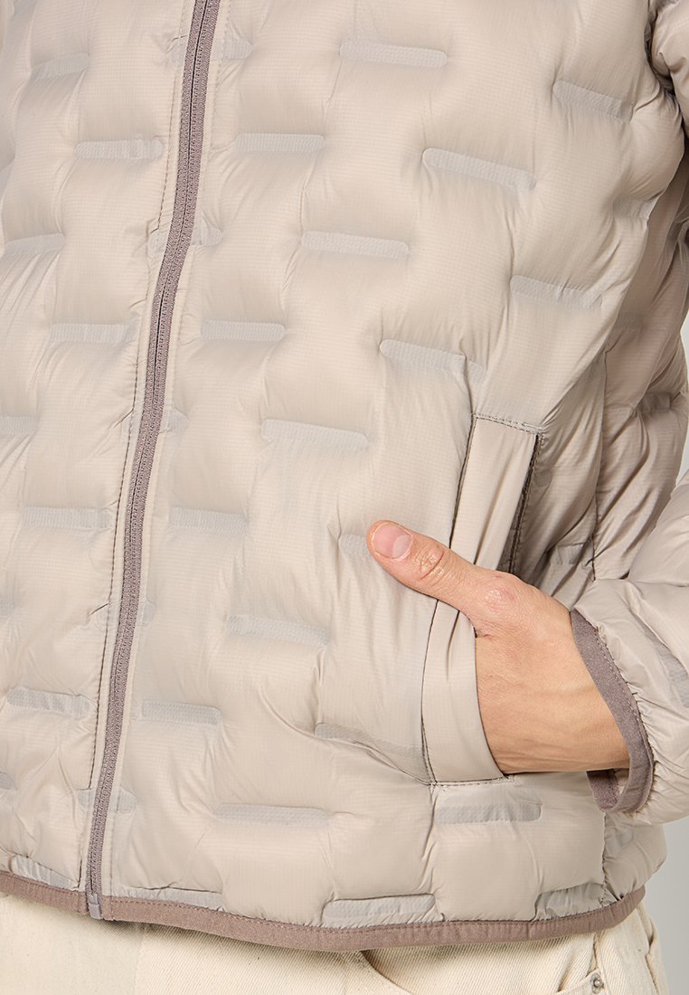 Beżowa kurtka puchowa z pikowaną strukturą, zamek błyskawiczny z przodu i bocznymi kieszeniami. Tkanina wydaje się lekka i gładka z kontrastowym wykończeniem.