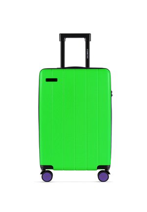 Valise rigide verte avec une surface texturée, des rainures verticales, une poignée rétractable noire et des roues violettes.