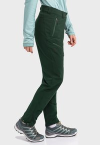 Green outdoor pants made of stretchy, water-resistant fabric, featuring two zippered side pockets and a tapered leg design.