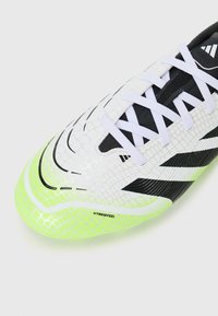 Football cleat featuring a white upper with black accents, textured pattern, and a bright neon green sole. Laces are white and traditional.