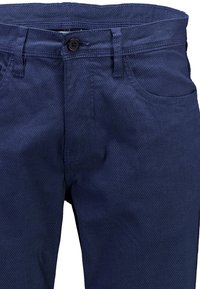 Pantaloni blu navy in tessuto strutturato, con chiusura a bottone, passanti per cintura e tasche frontali. Presentano un dettaglio con un motivo a diamante sottile.