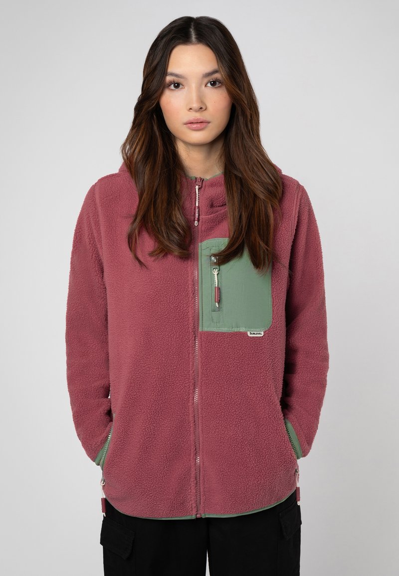 Bordeaux fleece hoodie met een groene borstzak; beschikt over een ritssluiting en een zachte textuur. Zoom en manchetten in contrasterend groen.
