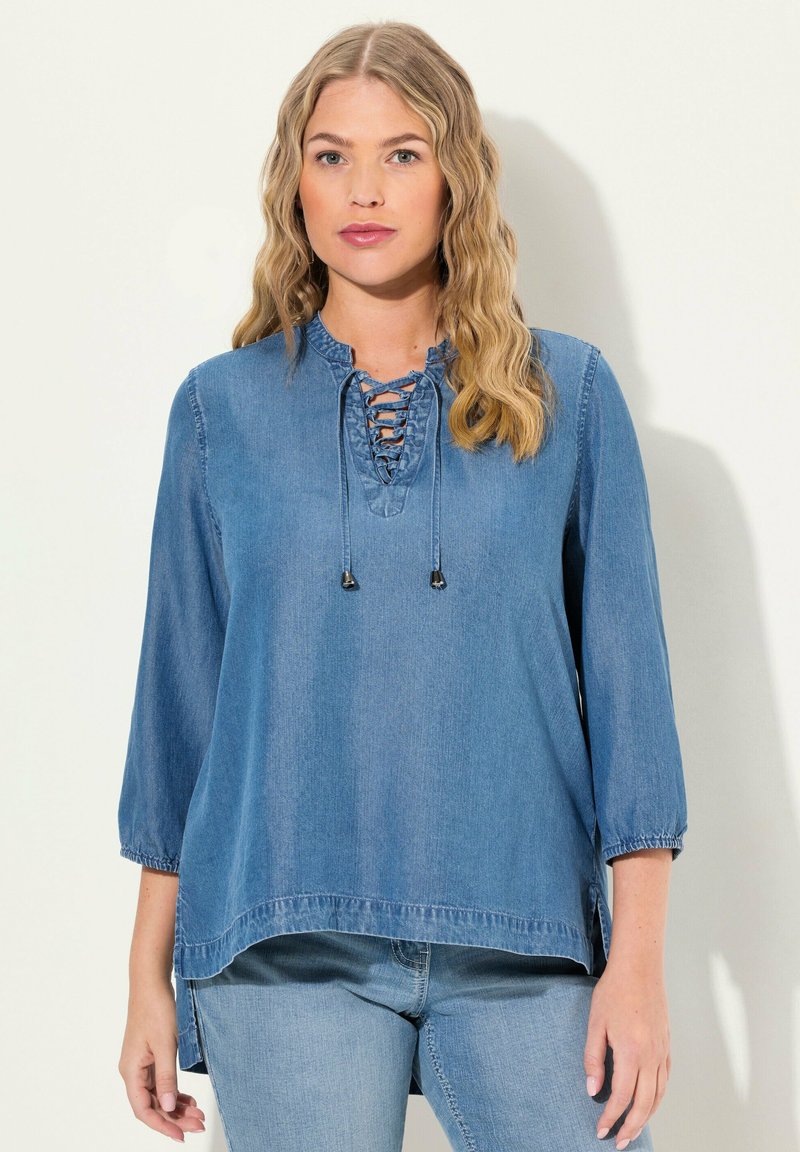 Top in denim con scollo tondo, apertura con lacci e maniche a tre quarti. Tessuto azzurro chiaro, vestibilità leggermente morbida, con spacchi laterali e polsini arricciati.