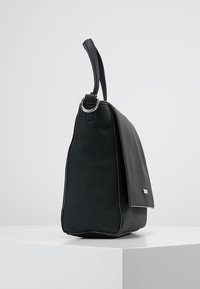 Svart läderhandväska med en strukturerad form, texturerad yta och en klaff med silverdetaljer. Inkluderar ett kort handtag för bärande.