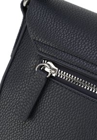 Schwarze, strukturiert-lederne Tasche mit Klappenverschluss, ausgestattet mit einem silbernen Reißverschluss und einem Zugtab, das ein elegantes Design und strapazierfähiges Material präsentiert.