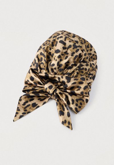 Μεταξωτό μαντήλι με animal print λεοπάρδαλης, με κεντρικό κόμπο και δύο μακριά άκρα που κρέμονται. Διαθέτει απαλό, λείο υφή και αποχρώσεις καφέ και μαύρου.