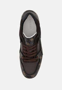 Sneaker marrone con un design a motivo, accenti in pelle liscia, punta perforata e lacci marroni su una base scura con un branding discreto.